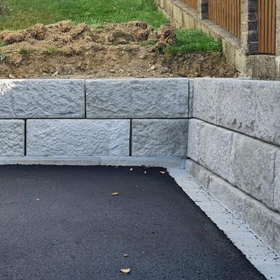 Stützwandsystem aus strukturierten Betonblöcken mit rechtwinkligem Eckanschluss – stabile Lösung zur Hangabsicherung im privaten Bereich