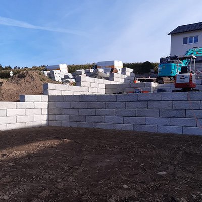 Klare Hangterrassierung mit Beton-Stützwänden – modernes System für Privatgärten mit Niveauunterschied