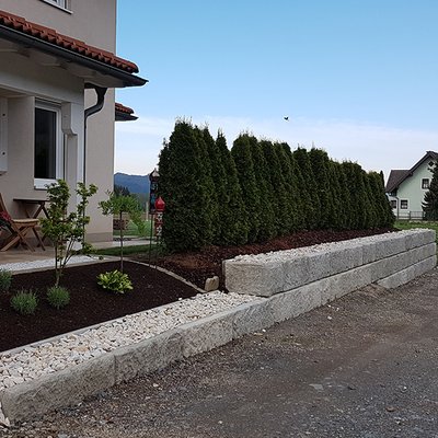 Niedrige Mauer aus Betonsteinen dient als elegante Einfriedung rund um das Haus